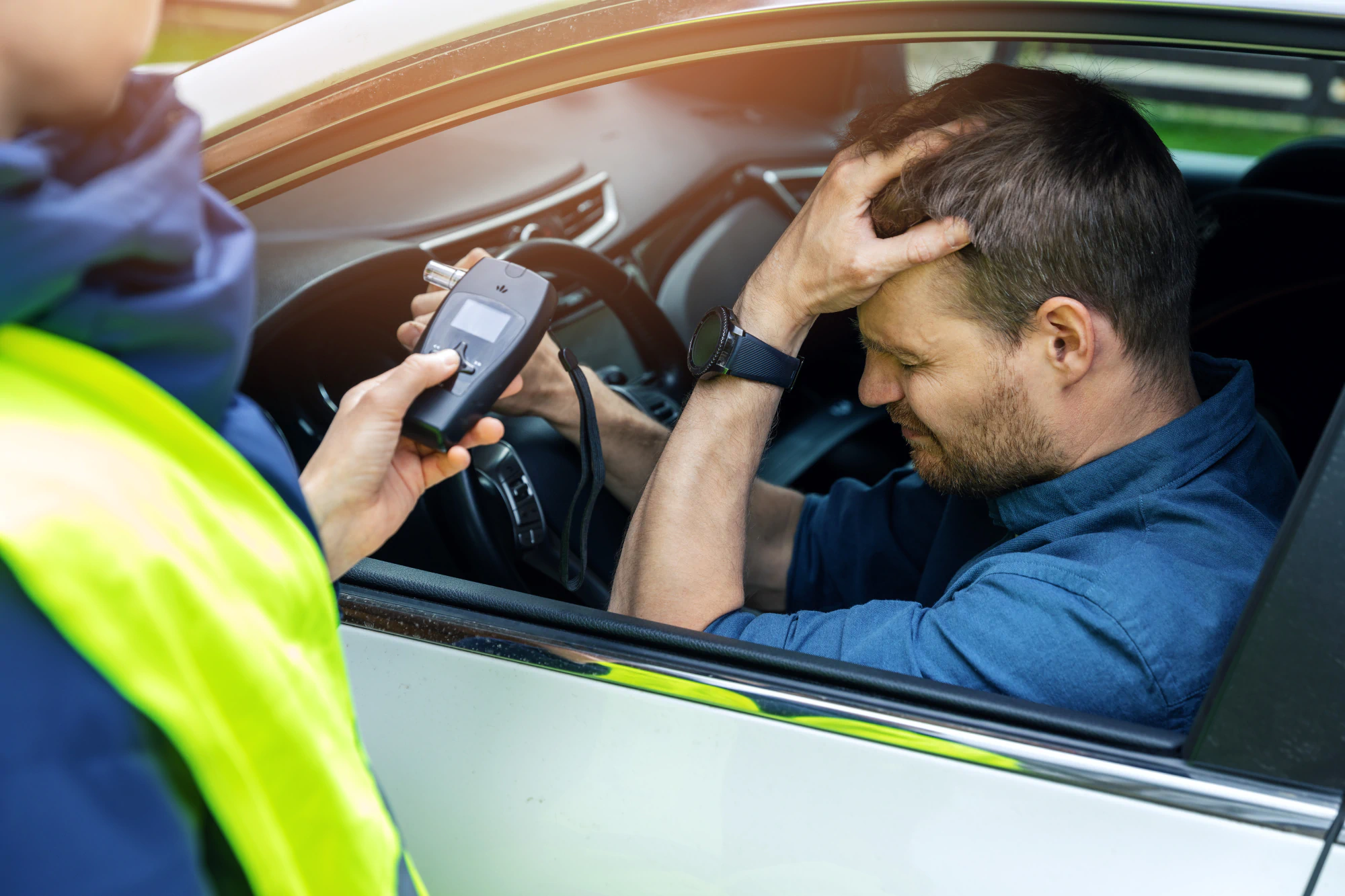 Man is crestfallen as officer presents him a breathalyzer test.