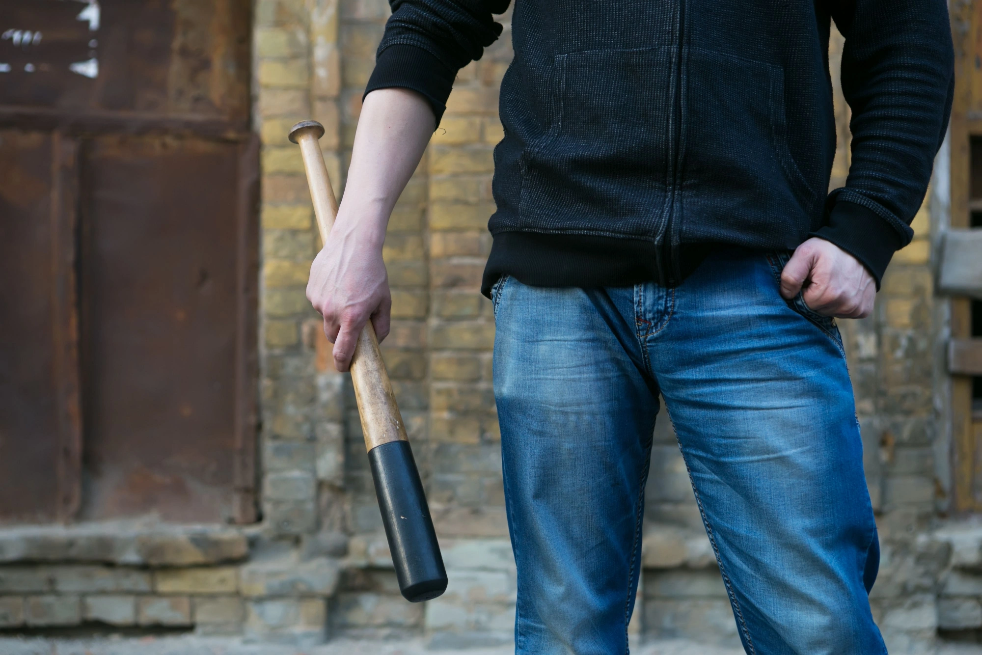 Man standing in the street with a baseball bat