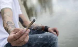 Man holding out a recreational marijuana joint
