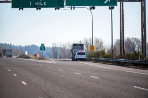 A big rig that has been pulled over by a police officer