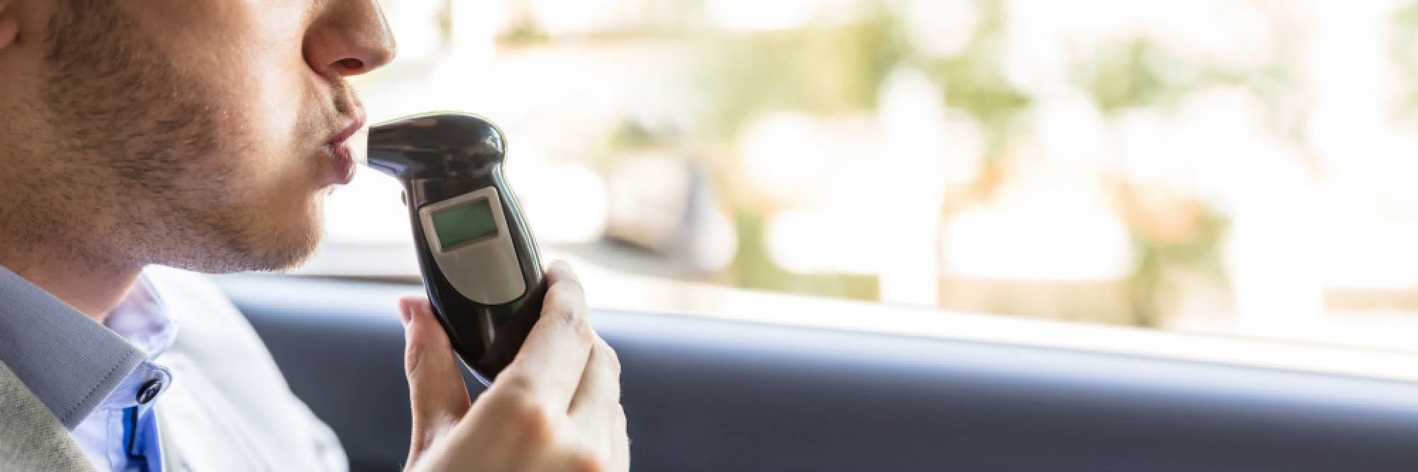 A motorist taking a breathalyzer test
