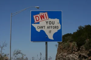 A street sign with an outline of the state of Texas and the words, “DWI, you can’t afford it.”