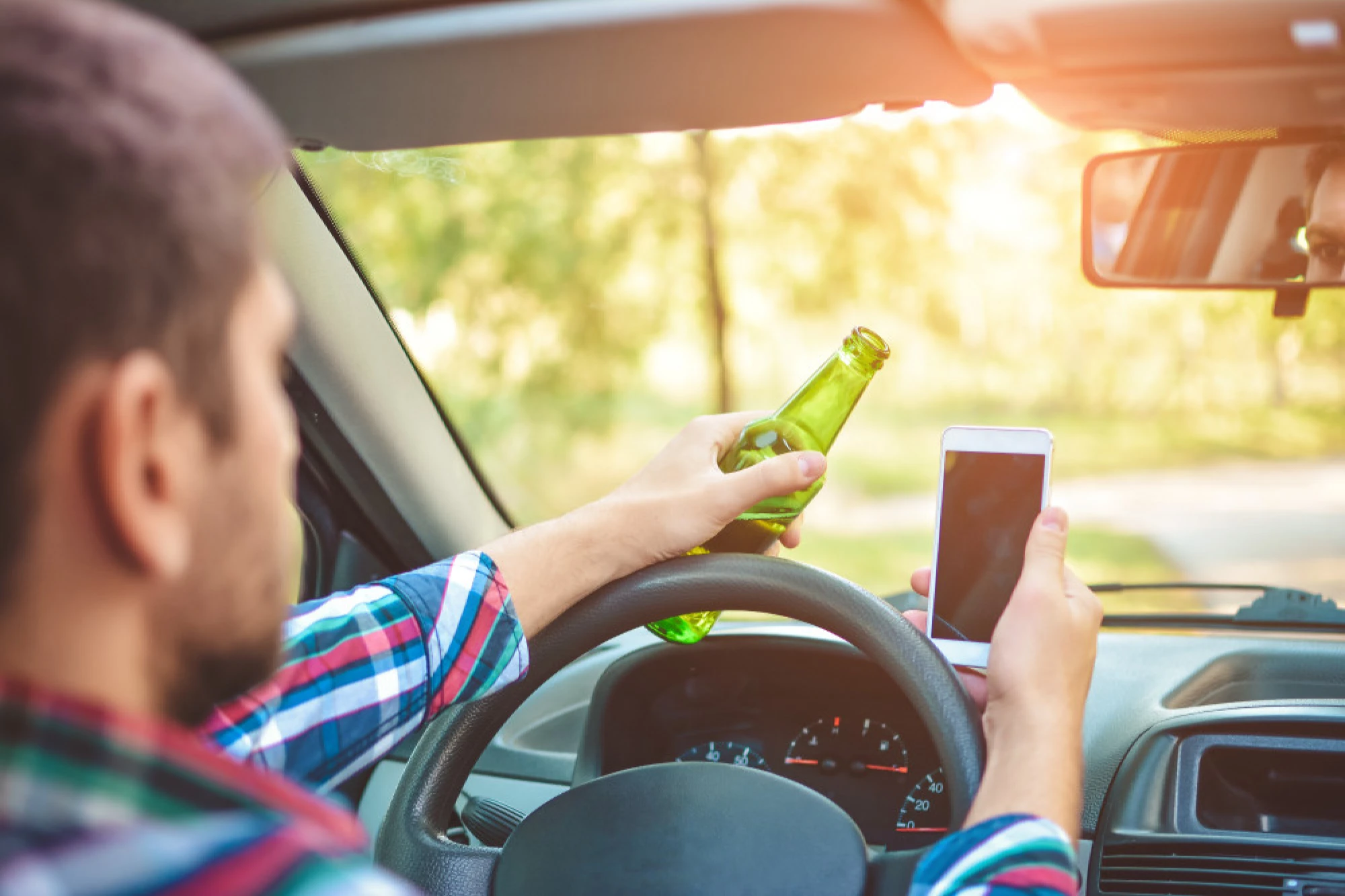 A man texting while drunk driving