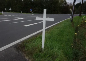 Una cruz blanca al borde de la carretera en memoria de un accidente mortal