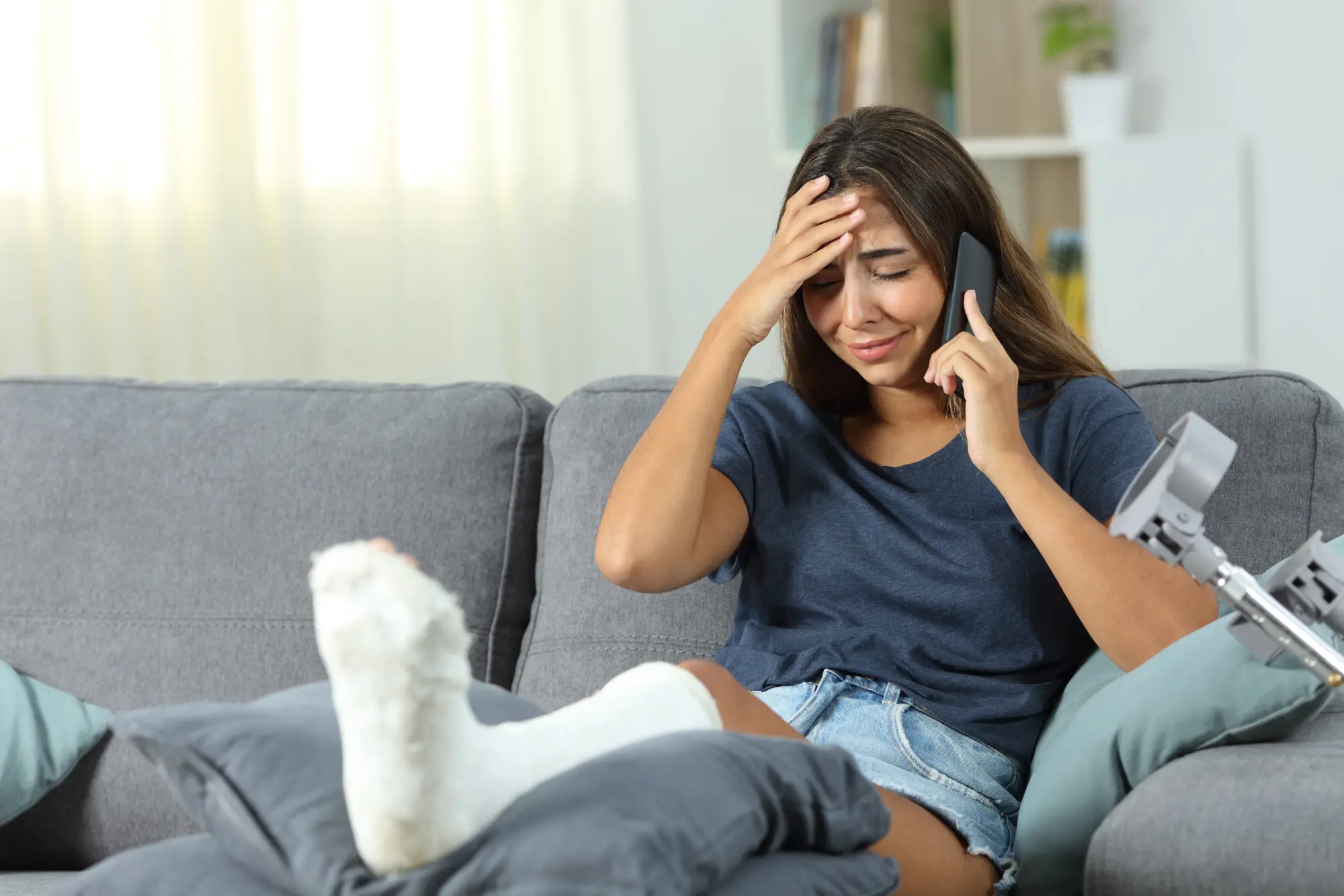 a woman with a cast on her leg on the phone with her insurance company