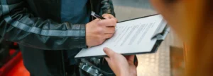 Un motociclista rellenando un formulario de reclamación al seguro