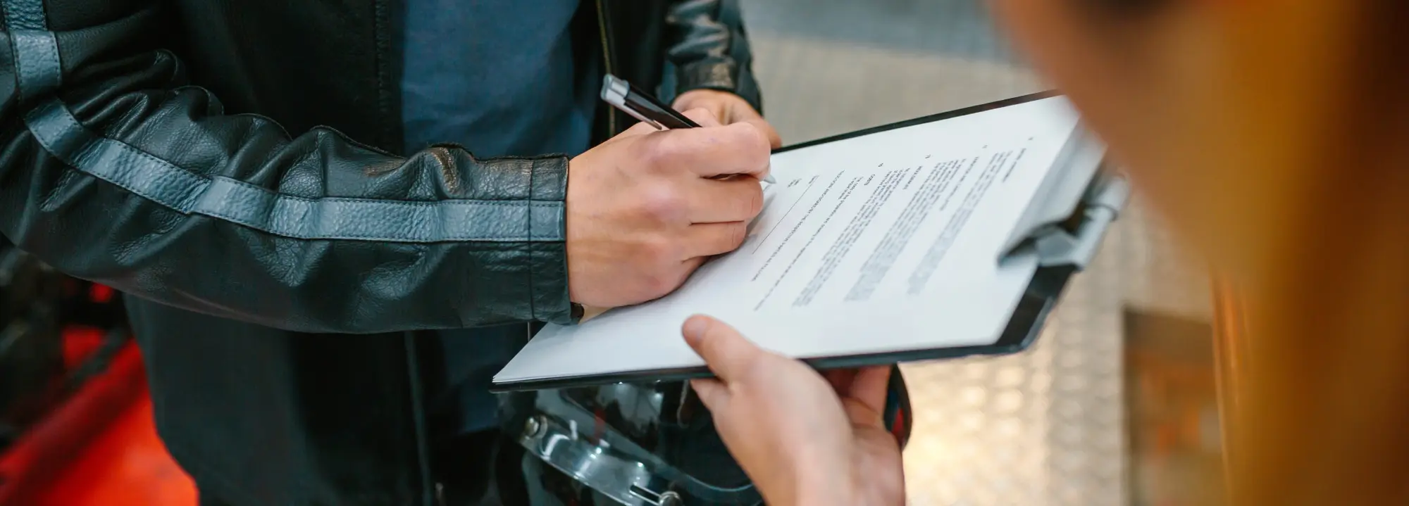 A motorcyclist filling out an insurance claim form