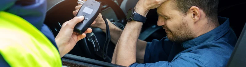 Man is crestfallen as officer presents him a breathalyzer test.