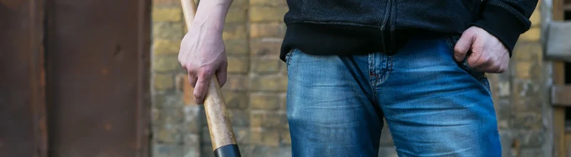 Man standing in the street with a baseball bat