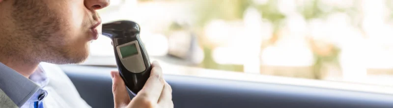 A motorist taking a breathalyzer test
