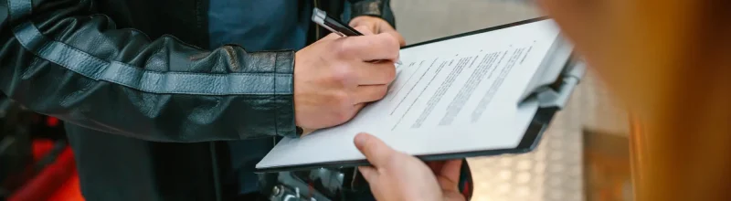 Un motociclista rellenando un formulario de reclamación al seguro