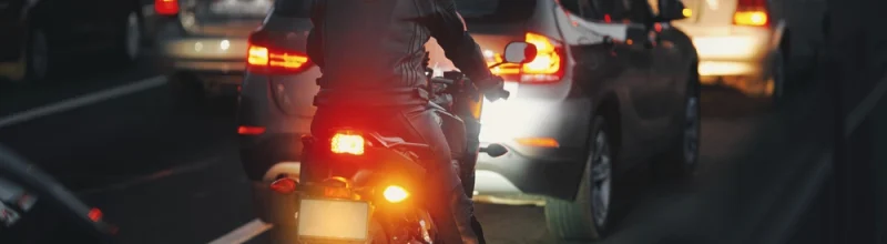 A motorcyclist waiting in traffic with other motorists